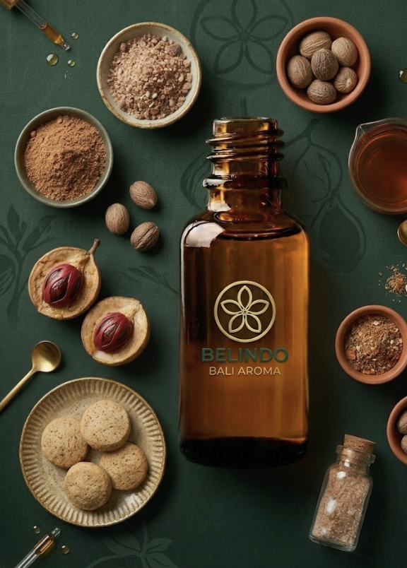 Nutmeg essential oil bottle surrounded by nutmeg, mace, spices and baked goods